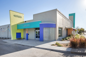 A modern, colorful public library building with geometric architecture under a clear blue sky in McLennan County, Texas.