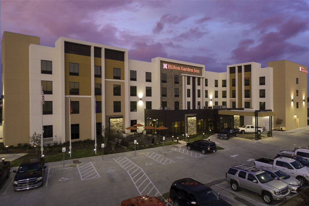 A Hilton Garden Inn hotel exterior at dusk with a parking lot in front in McLennan County, Texas.