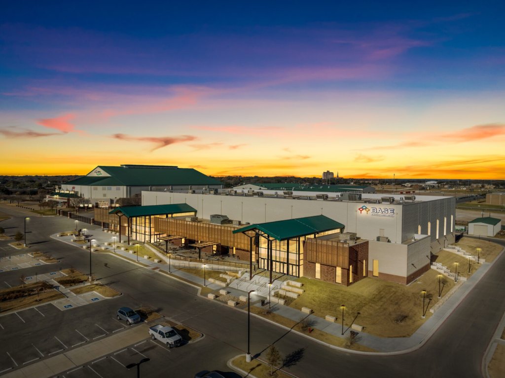 An aerial view of a large modern building complex during a vibrant sunset in McLennan County, Texas.