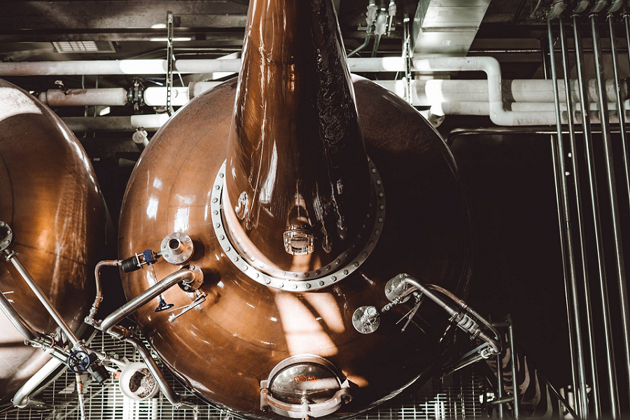 A large copper pot still used for distilling spirits in a factory setting in McLennan County, Texas.