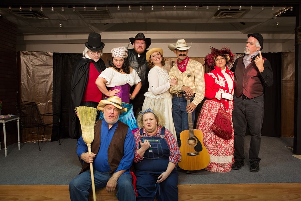 A group of people in various historical and theatrical costumes posing on a stage in McLennan County, Texas.
