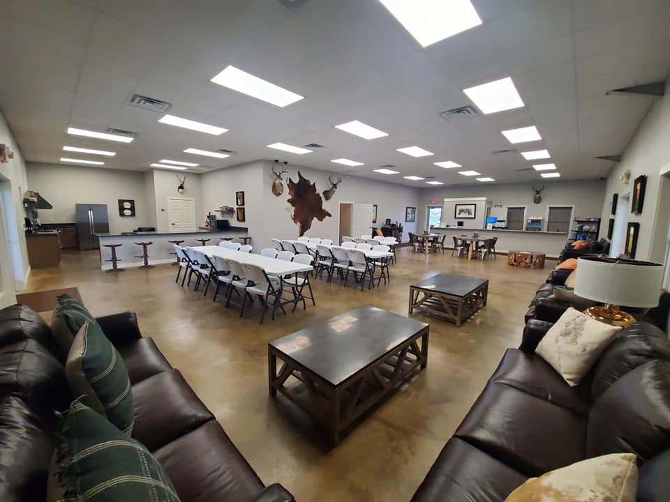 A large, open-plan event space with leather sofas, dining tables, and rustic decor in McLennan County, Texas.