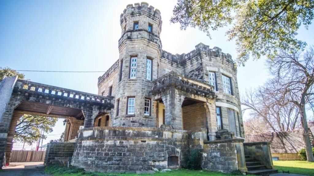 A historic stone castle-like building with a tower and a covered entrance in McLennan County, Texas.
