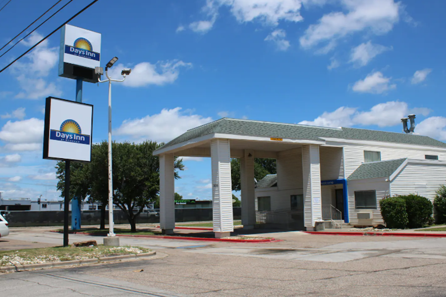 A Days Inn hotel building with a prominent sign under a bright blue sky in McLennan County, Texas.
