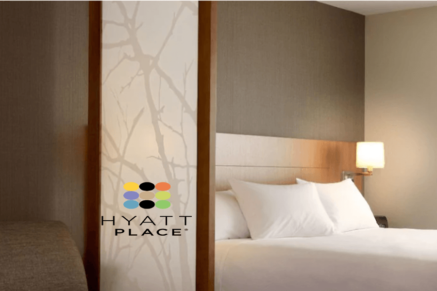 A modern hotel room interior with a Hyatt Place logo on a decorative screen in McLennan County, Texas.
