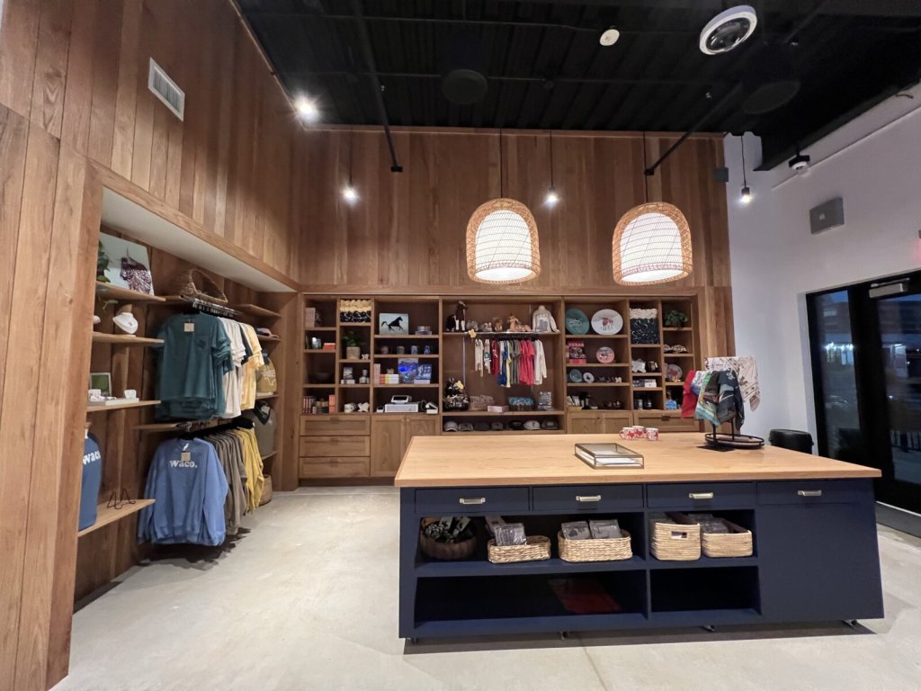 A modern retail store interior with wooden walls, shelves of merchandise, and a large counter in McLennan County, Texas.