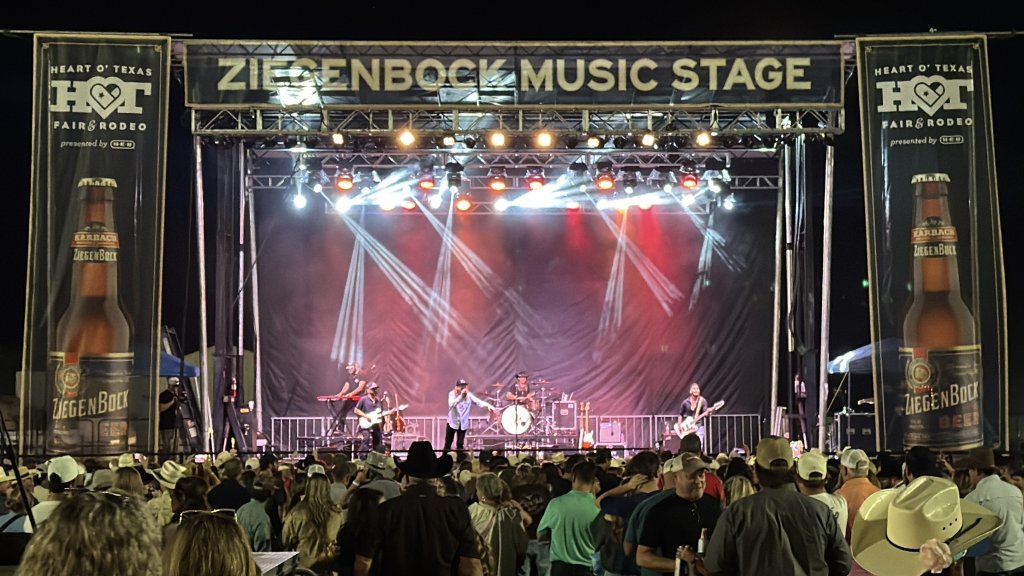 A live band performs on the Ziegenbock Music Stage before a large outdoor crowd in McLennan County, Texas.