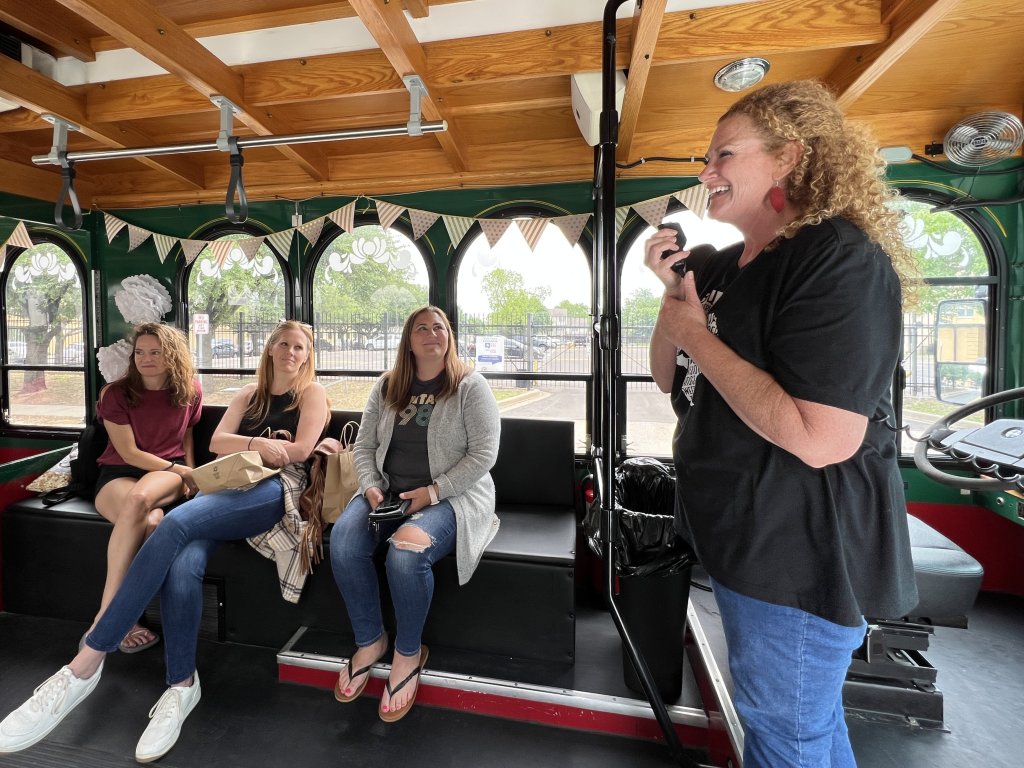 A woman speaks into a microphone on a trolley while three women listen in McLennan County, Texas.