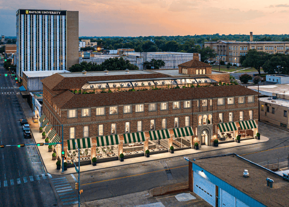 An aerial view of a brick building with green awnings at sunset in McLennan County, Texas.