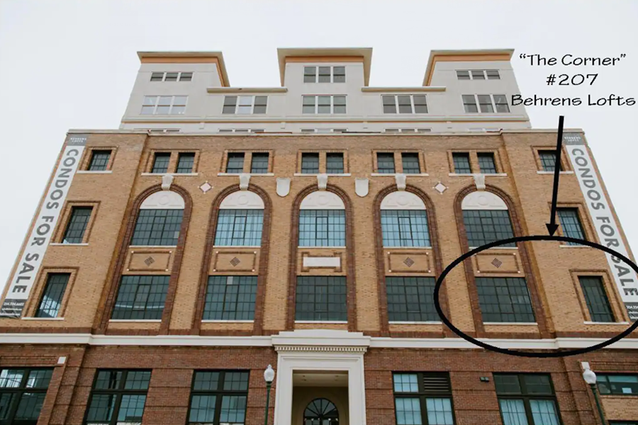 A brick building with a sign indicating condos for sale and a highlighted unit in McLennan County, Texas.