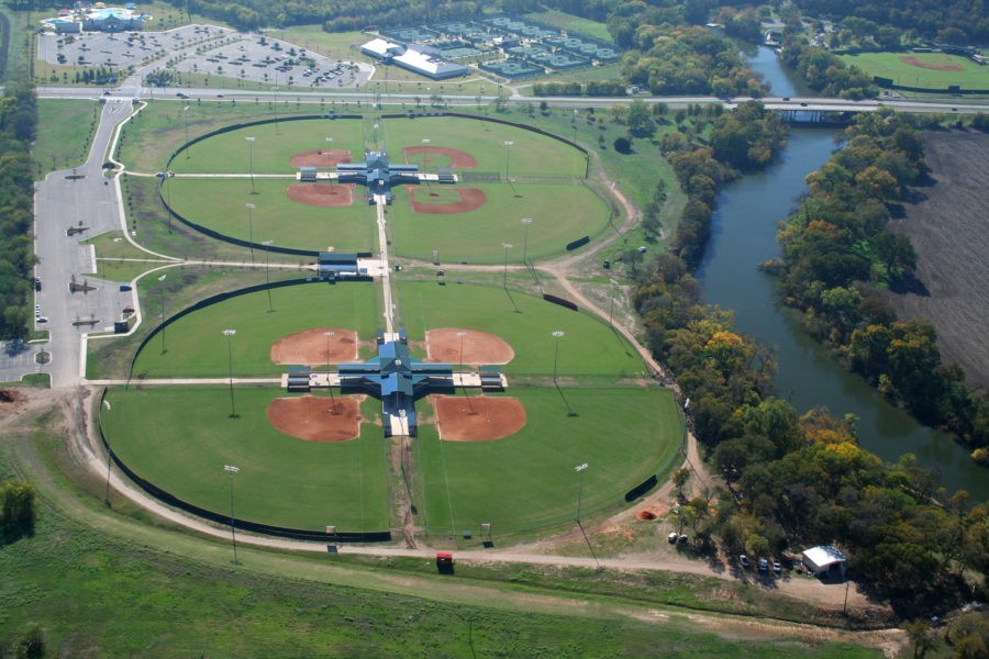 An aerial view of two baseball complexes situated next to a winding river in McLennan County, Texas.