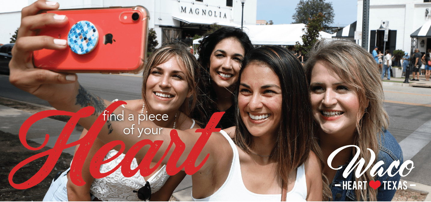 Four smiling women taking a selfie together outdoors in front of a building in McLennan County, Texas.