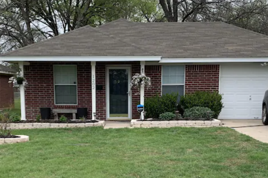 A single-story brick house with a front porch, lawn, and attached garage in McLennan County, Texas.