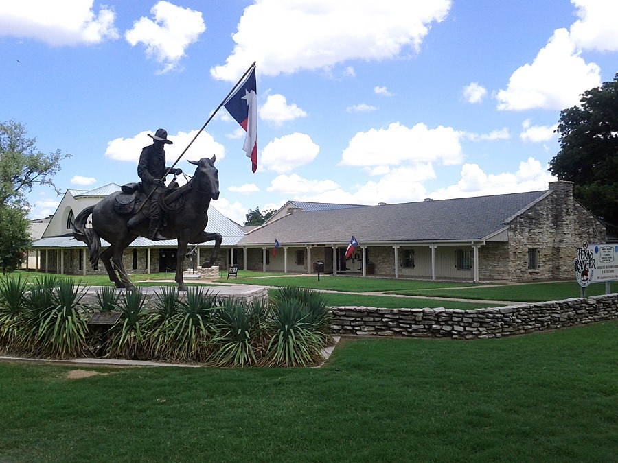 A bronze statue of a Texas Ranger on horseback holding a Texas flag in McLennan County, Texas.