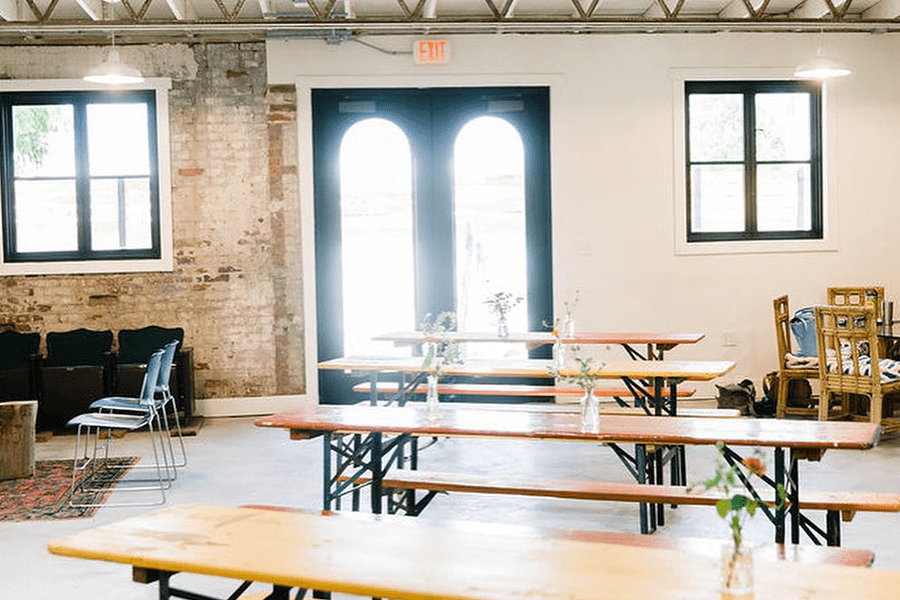 A bright, open room with long wooden tables and chairs in a rustic setting in McLennan County, Texas.