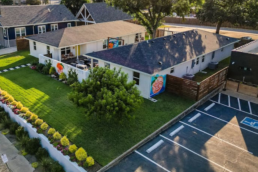 An aerial view of a white building with peach murals and a parking lot in McLennan County, Texas.