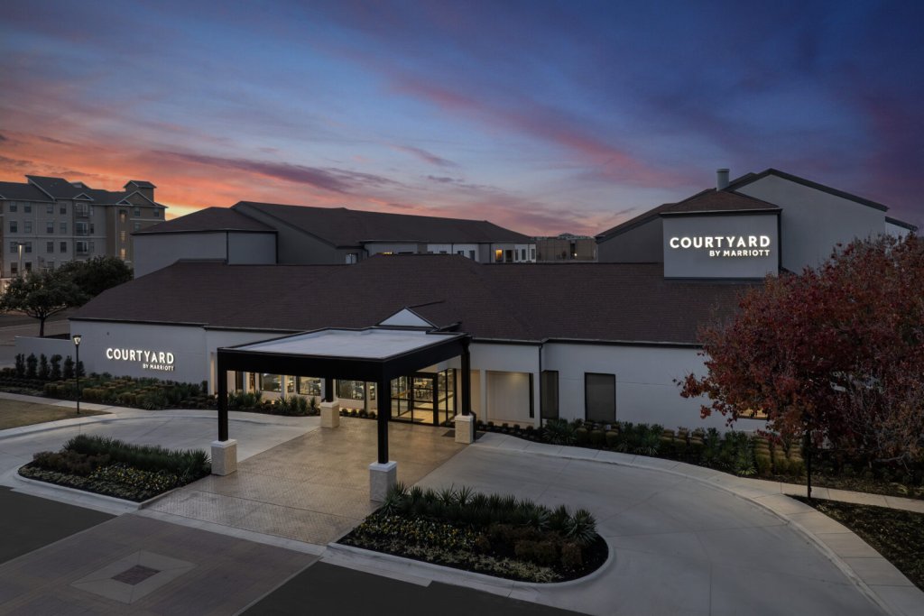 A Courtyard by Marriott hotel exterior at sunset with a dramatic colorful sky in McLennan County, Texas.