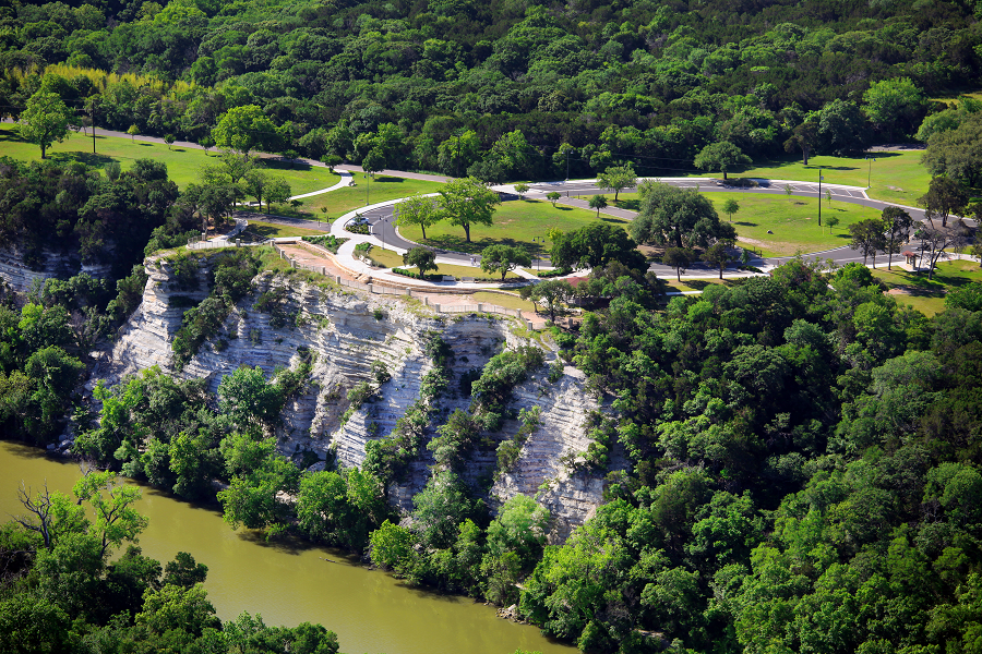 An aerial view of a limestone cliff overlooking a river near a park in McLennan County, Texas.