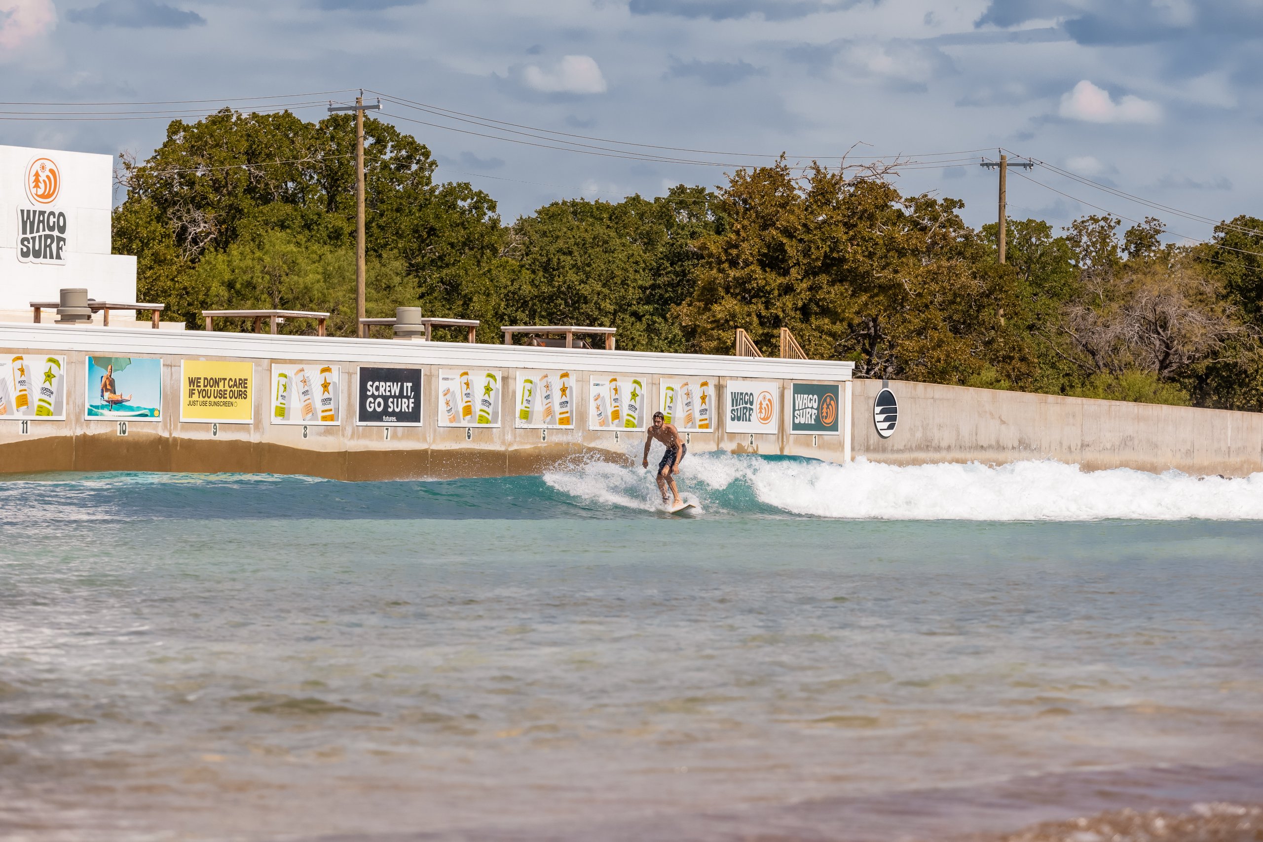A surfer rides a wave at a man-made surf park facility in McLennan County, Texas.