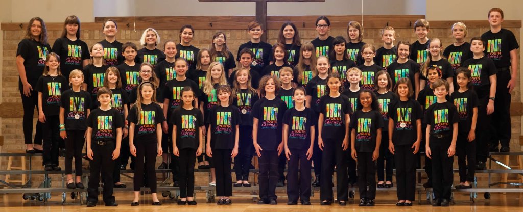 A large youth choir posing for a group photo on tiered risers in McLennan County, Texas.