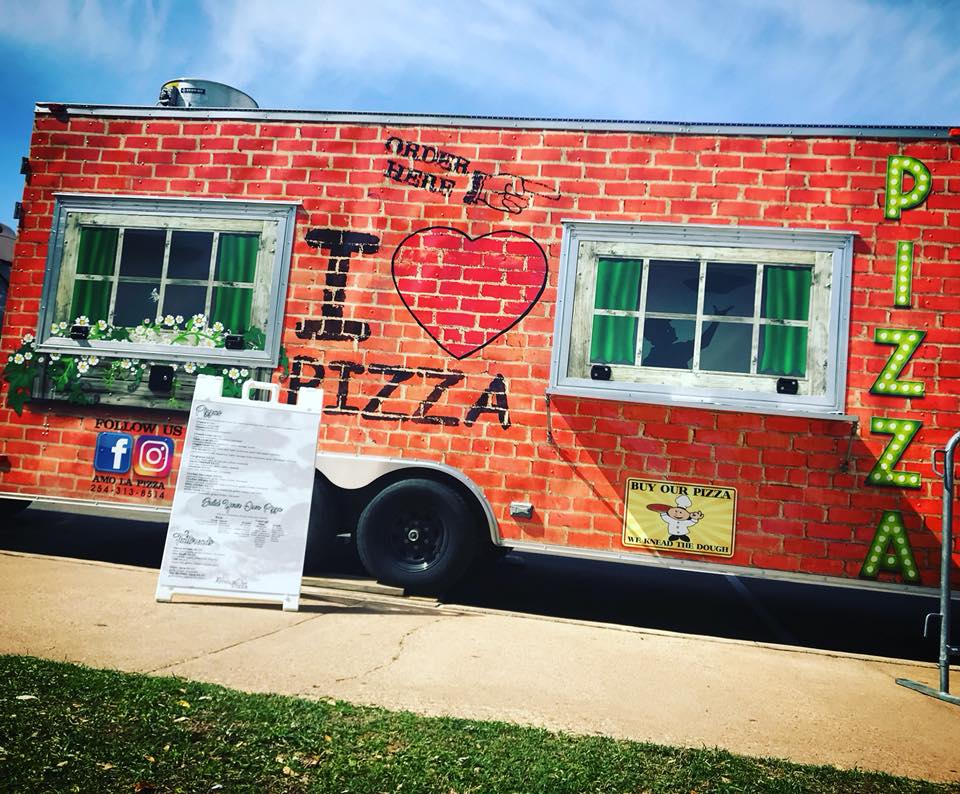 A food truck with a brick pattern exterior and pizza-themed decorations in McLennan County, Texas.