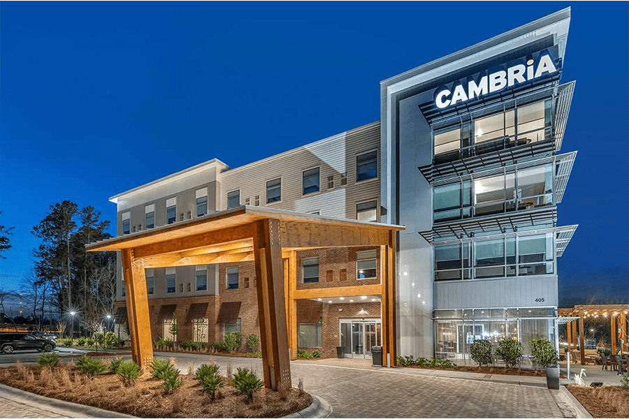 A modern Cambria hotel building exterior at twilight with a wooden entrance canopy in McLennan County, Texas.