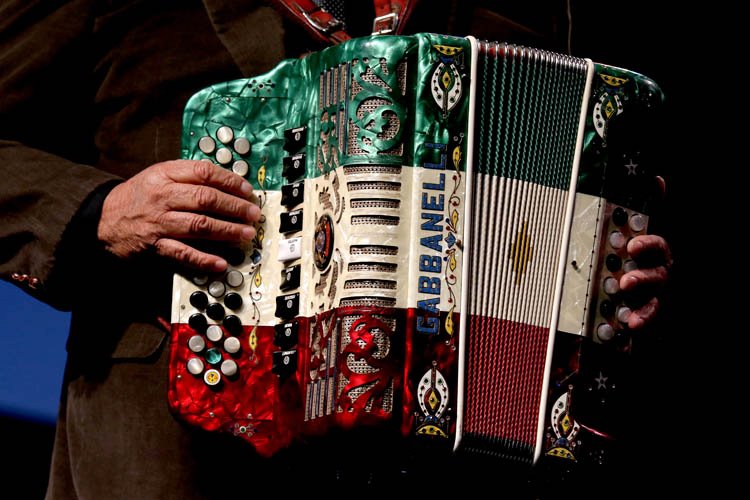 A musician plays a decorative Gabbanelli accordion with Mexican flag colors in McLennan County, Texas.