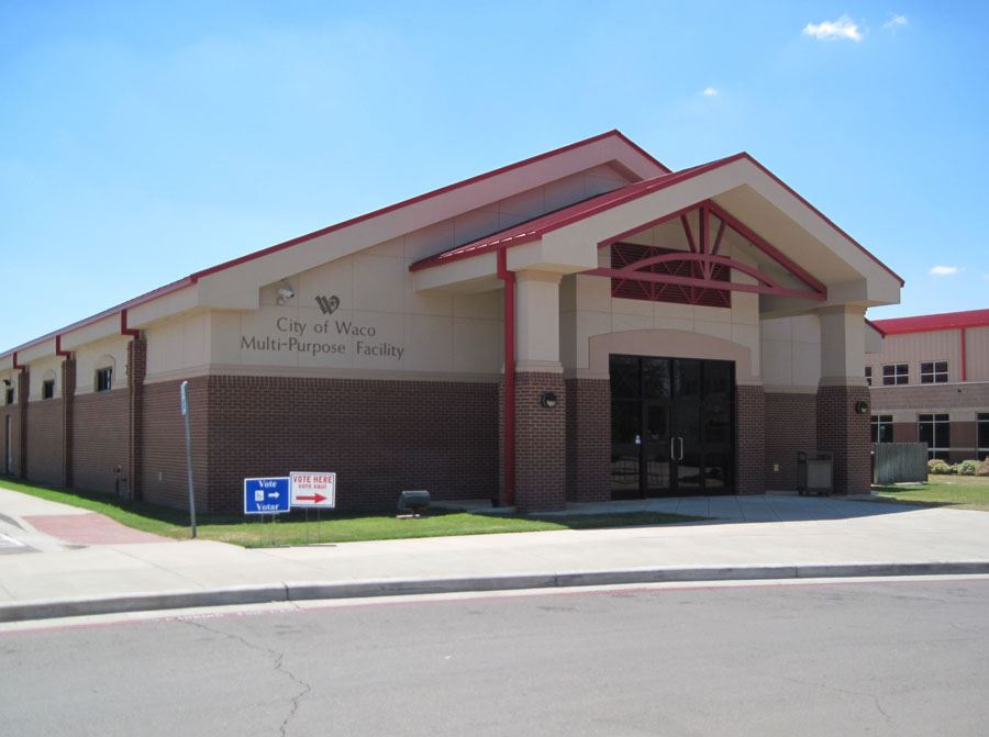 The City of Waco Multi-Purpose Facility building with voting signs on the lawn in McLennan County, Texas.