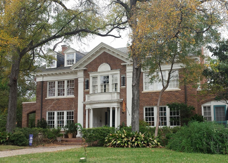 A large, two-story brick house with white trim and a front porch in McLennan County, Texas.