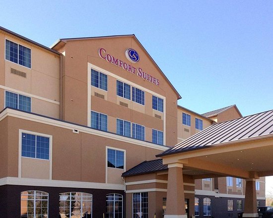 The exterior of a Comfort Suites hotel building under a clear blue sky in McLennan County, Texas.
