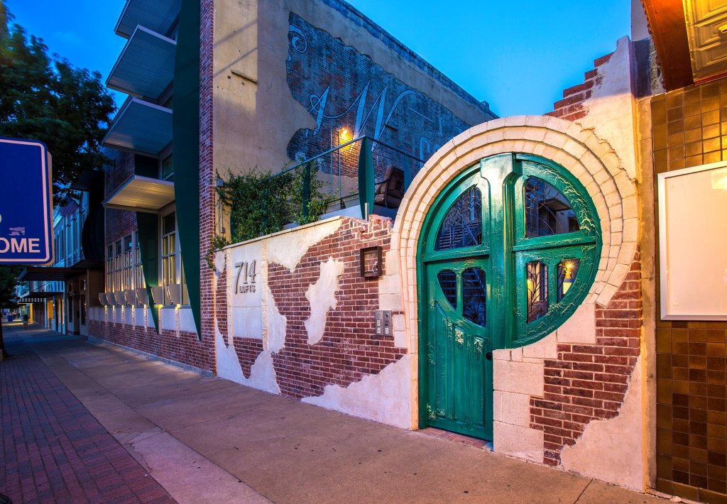 A unique green circular door set into a brick wall at twilight in McLennan County, Texas.