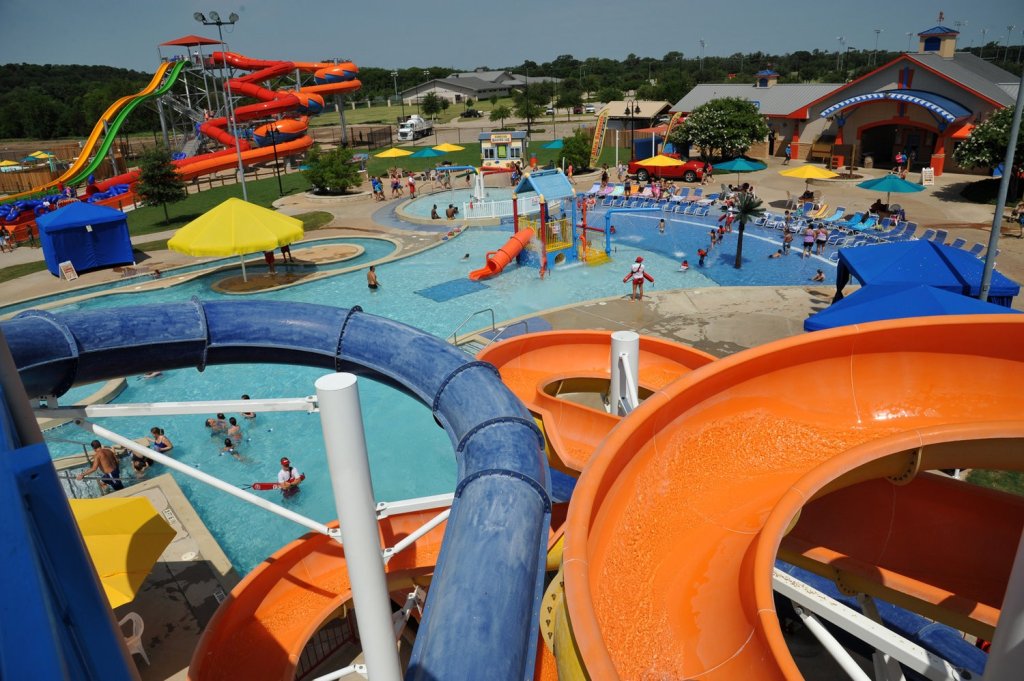 A high-angle view of a colorful outdoor water park with slides and swimming pools in McLennan County, Texas.