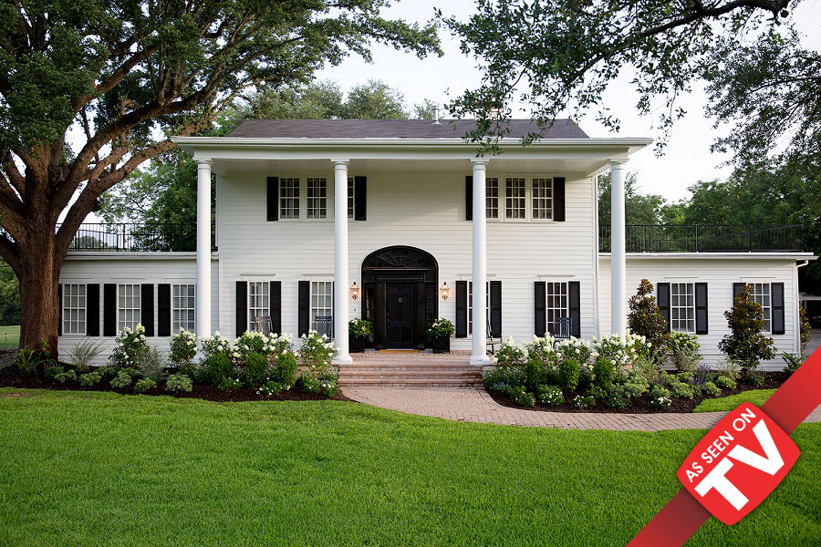 A white two-story colonial house with black shutters and a large front porch in McLennan County, Texas.