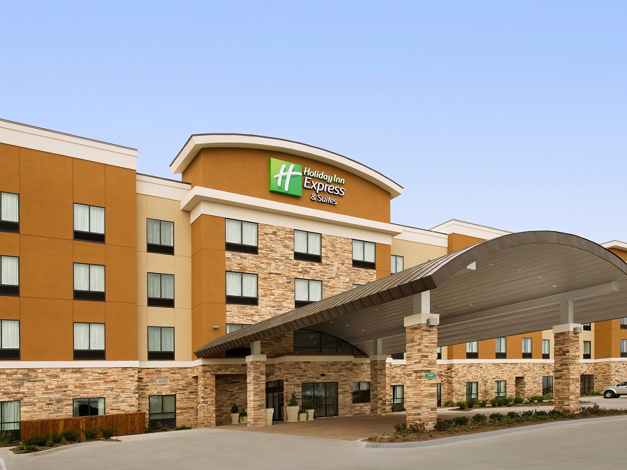 The exterior of a modern Holiday Inn Express and Suites hotel building in McLennan County, Texas.