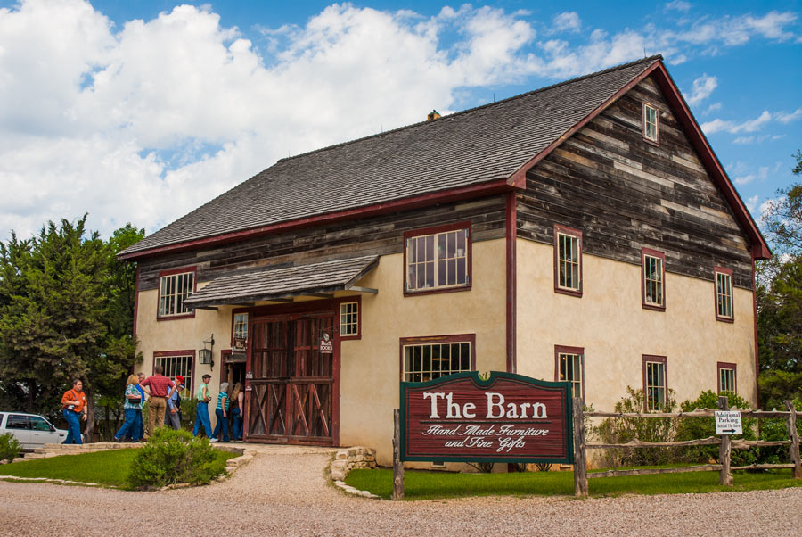 A rustic barn building with a sign for handmade furniture and fine gifts in McLennan County, Texas.