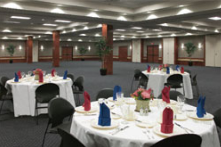 A large, empty banquet hall featuring round tables set with red and blue napkins in McLennan County, Texas.