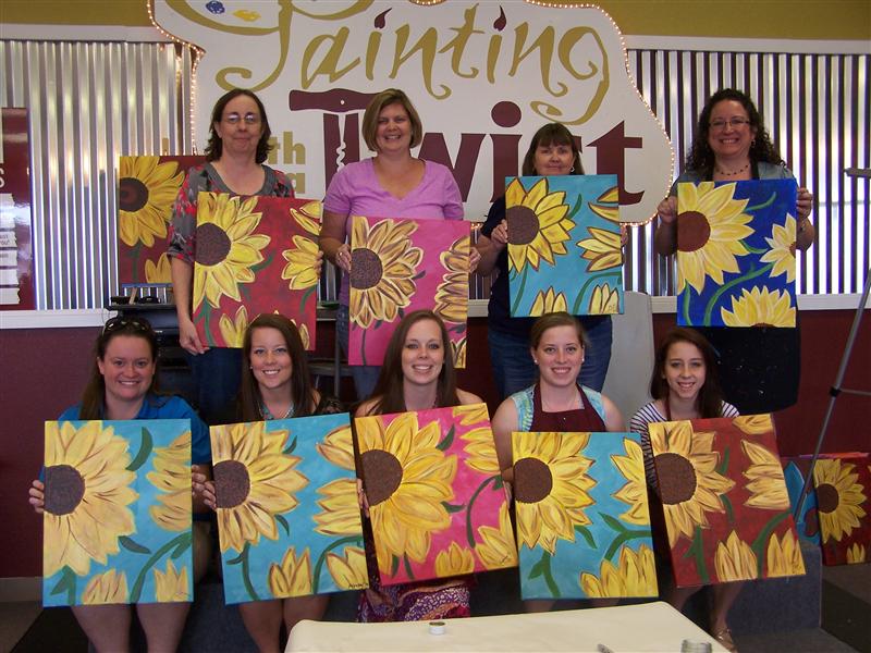 A group of women holding their sunflower paintings at a painting class in McLennan County, Texas.
