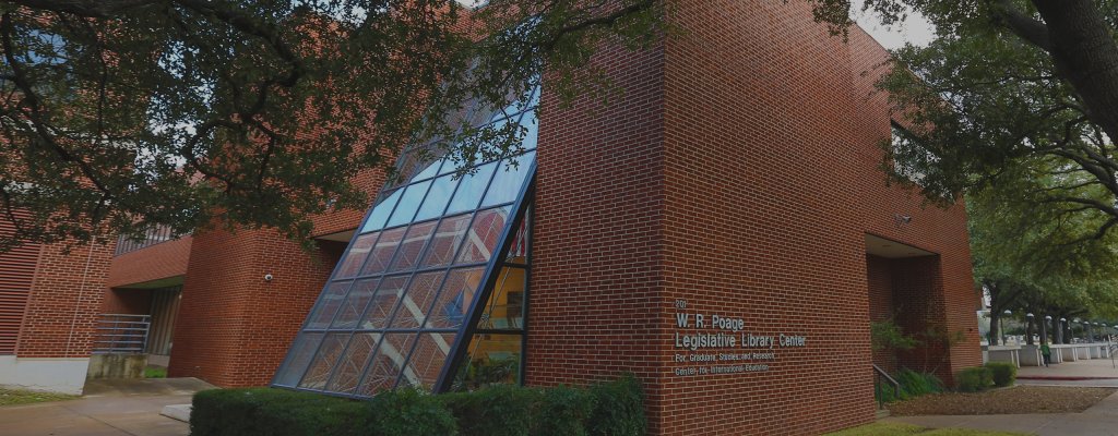 The W.R. Poage Legislative Library Center building featuring red brick and a slanted glass facade in McLennan County, Texas.