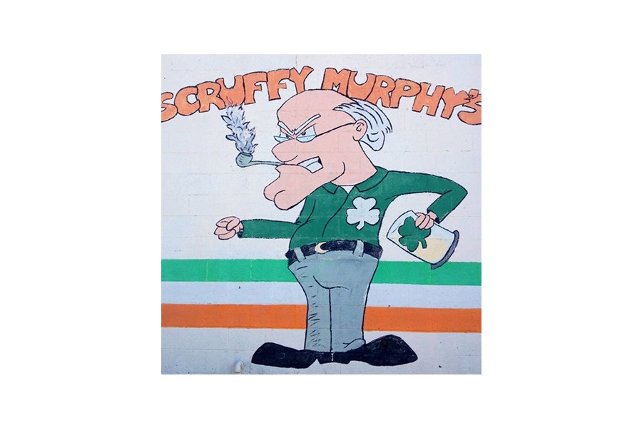A cartoon mural of an angry man smoking a pipe and holding a beer in McLennan County, Texas.