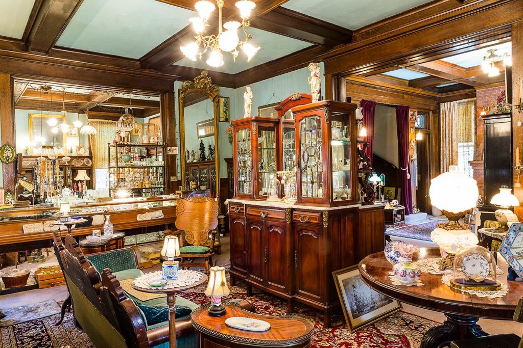 An antique shop interior filled with vintage furniture, glass display cabinets, and decorative lamps in McLennan County, Texas.
