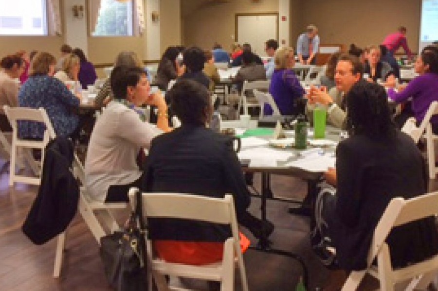 A group of people sitting at round tables in a conference room in McLennan County, Texas.