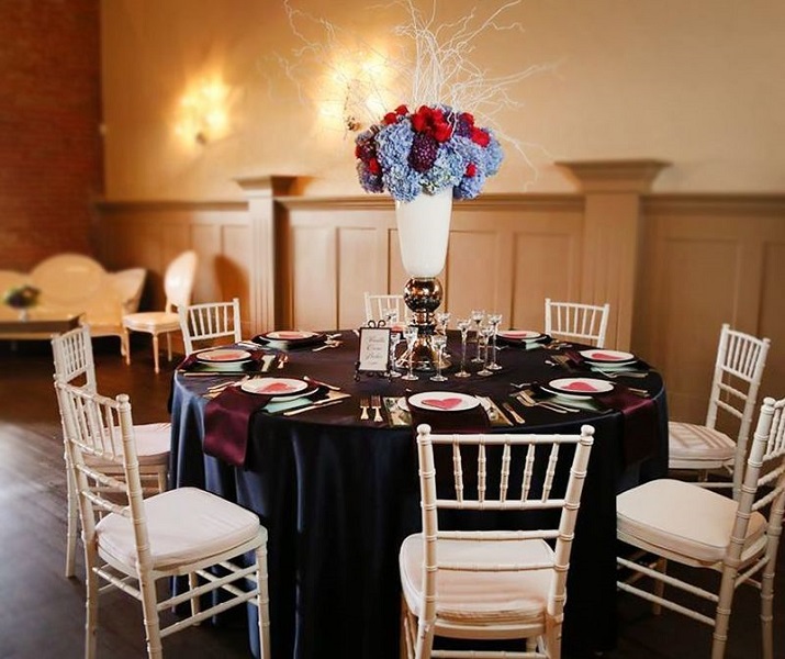 A round table set for a formal event with a large floral centerpiece in McLennan County, Texas.