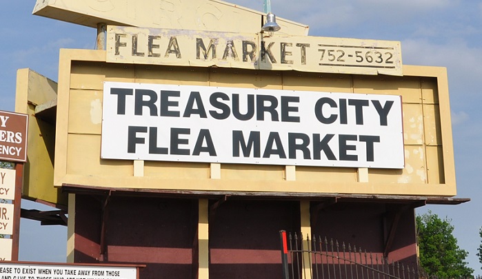 A large outdoor sign for the Treasure City Flea Market in McLennan County, Texas.