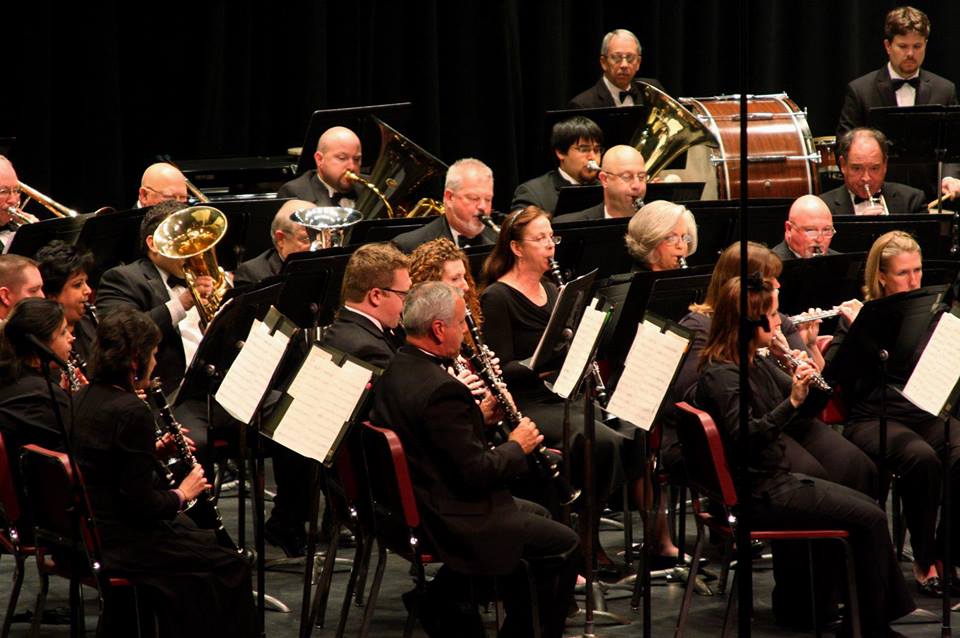 A concert band performing on stage with musicians playing various instruments in McLennan County, Texas.