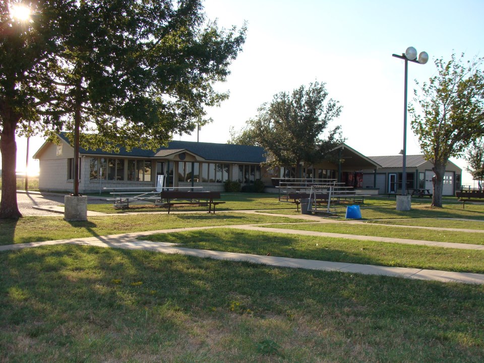 A low-rise building with a grassy lawn and benches during a sunny day in McLennan County, Texas.