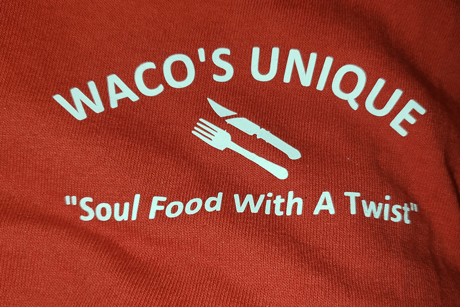 A red fabric surface with white text reading Waco's Unique Soul Food With A Twist in McLennan County, Texas.