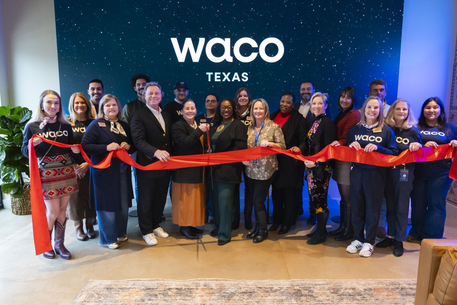 A diverse group of people participating in a ribbon-cutting ceremony in Waco, Texas in McLennan County, Texas.