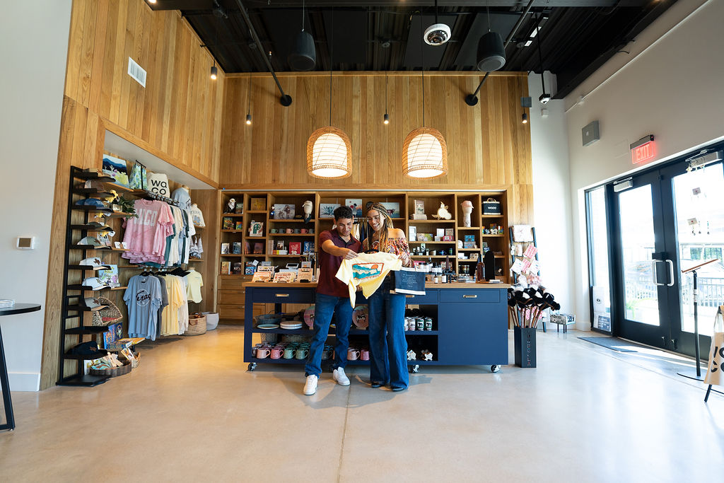 A man and woman browse merchandise inside a modern retail shop with wooden walls in McLennan County, Texas.