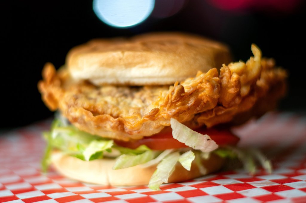 A crispy fried chicken sandwich on a red and white checkered paper in McLennan County, Texas.