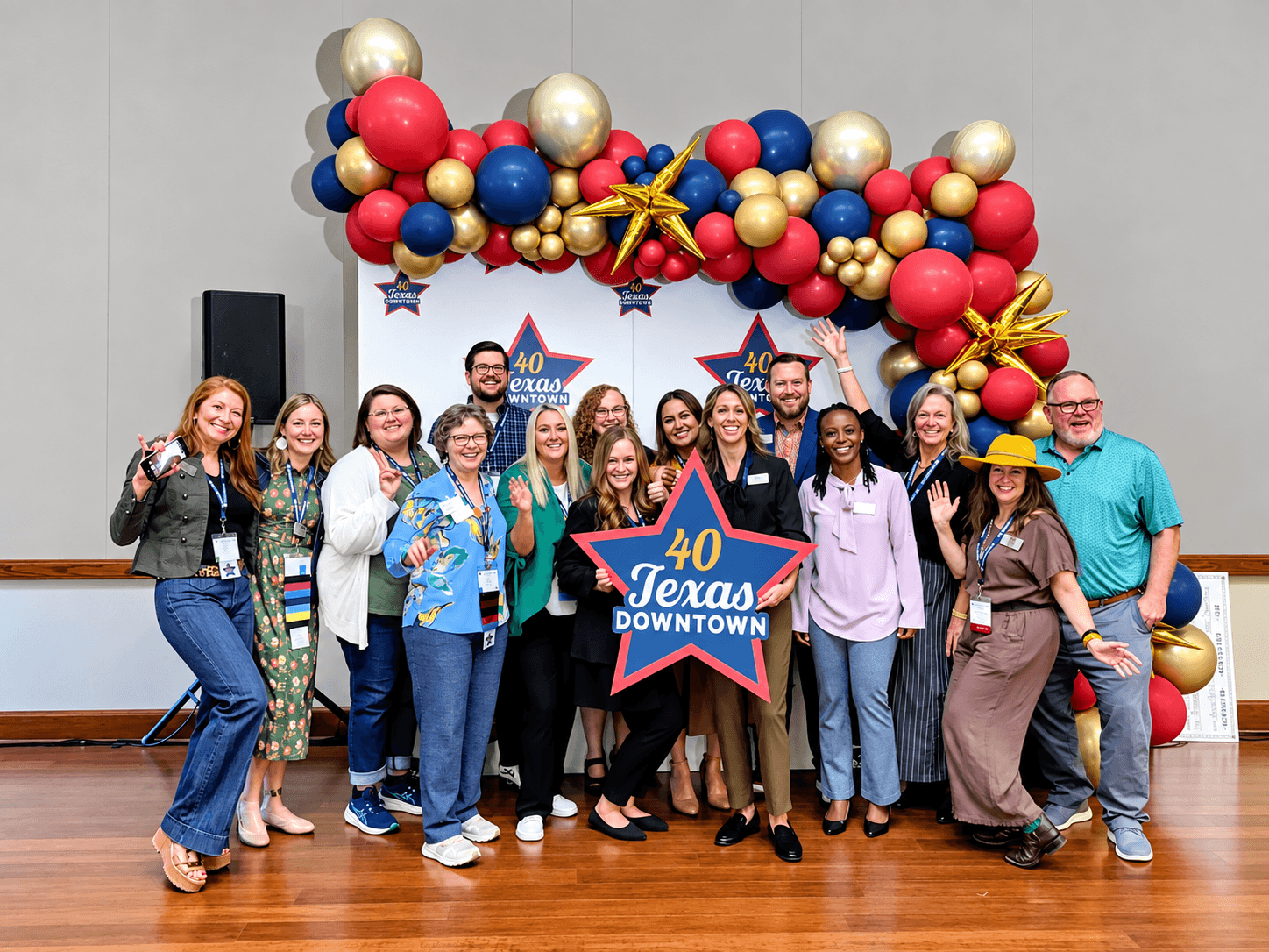 A group of people posing for a photo in front of a balloon arch in McLennan County, Texas.